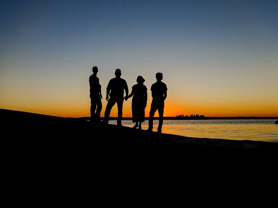 Silueta de una familia unida frente al mar al atardecer
